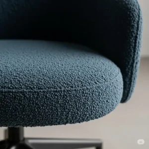 Close-up view of the luxurious boucle fabric on a swivel office chair, emphasizing its unique texture.