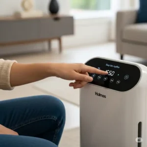 User interacting with the easy-to-use digital controls on a Holmes air purifier.