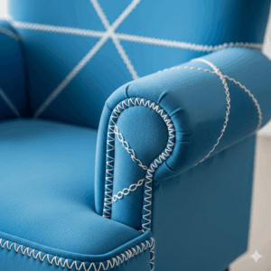 A close-up shot of a small upholstered chair in a vibrant blue color with intricate stitching details.