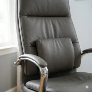 Close-up of the adjustable lumbar support and padded armrests on a grey leather desk chair.