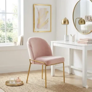 A stylish vanity area featuring a chic light pink desk chair gold legs no wheels.