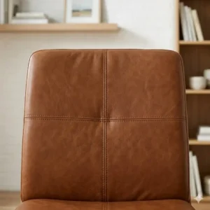 Close-up view of the premium stitched upholstery on an armless leather desk chair highlighting the material texture.